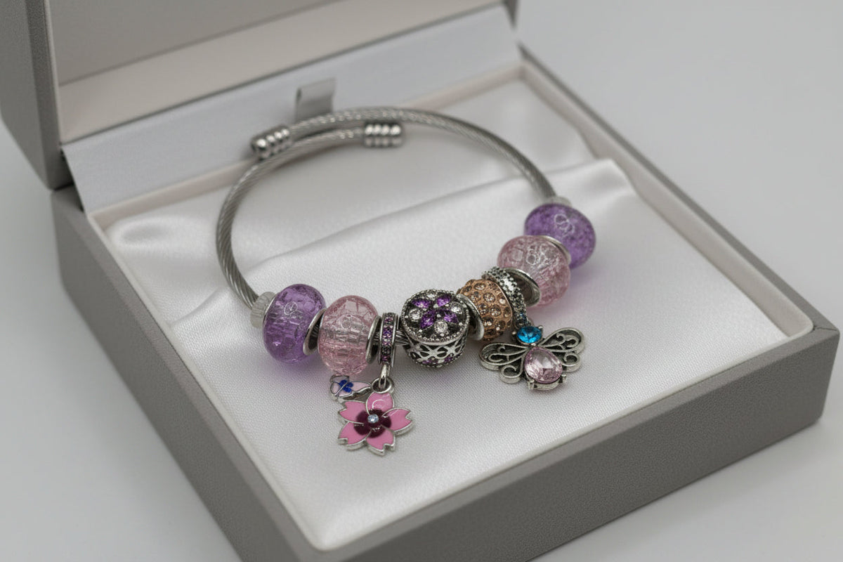 Gold rose charm bracelet with textured beads and dangling rose pendant