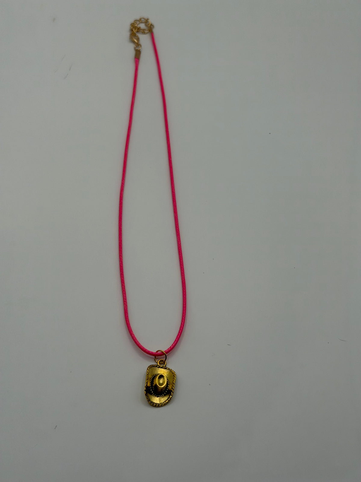 Pink cord necklace with gold cowboy hat charm