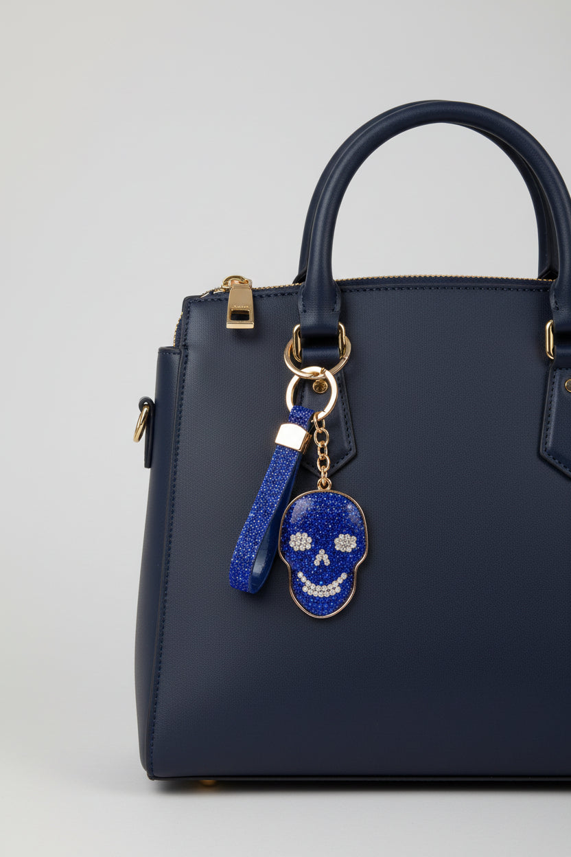 Blue rhinestone skull keychain with crystal flower eyes and gold border