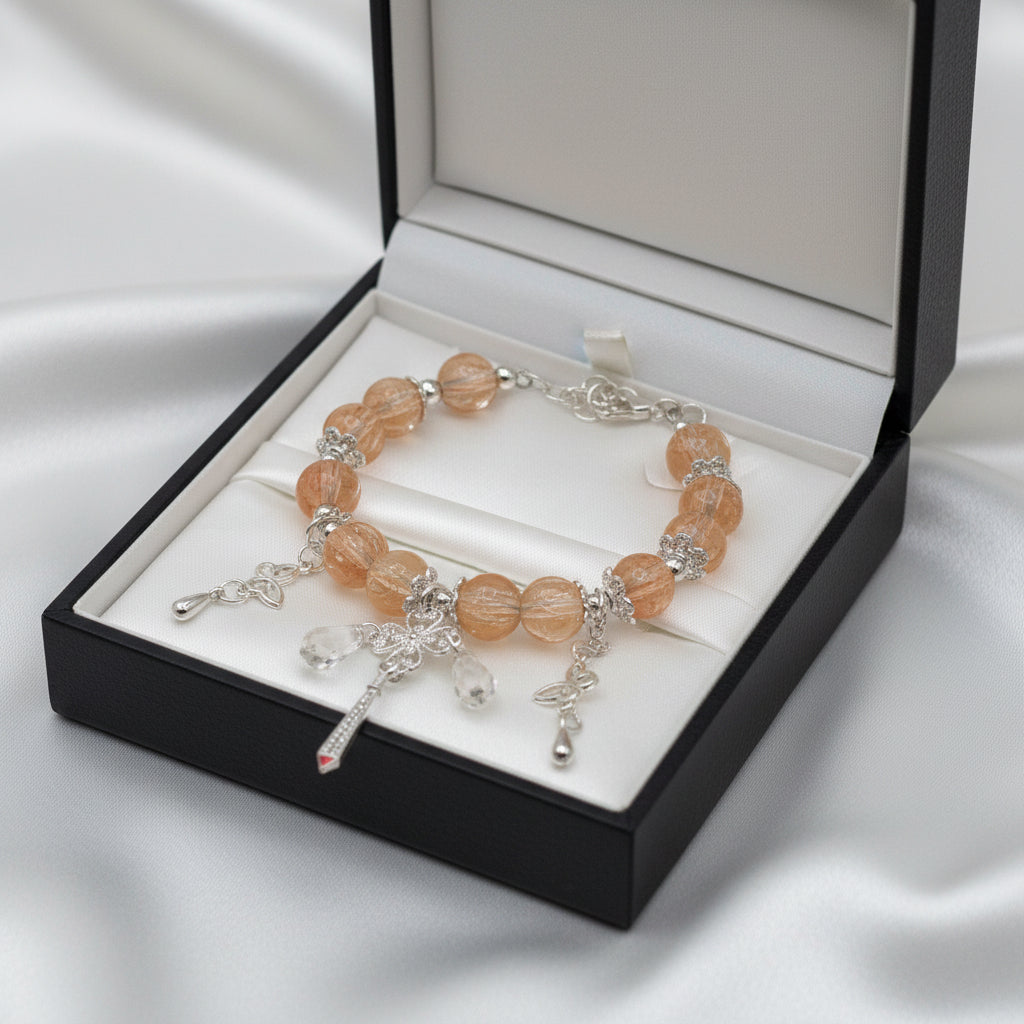 Peach crystal bead bracelet with butterfly and clover drop charms