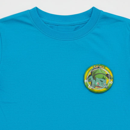 Pokémon Bulbasaur button pin and matching collectible card set on white background