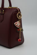Strawberry dress charm keychain with watermelon slice, black rose charm, and red orb bead on gold chain