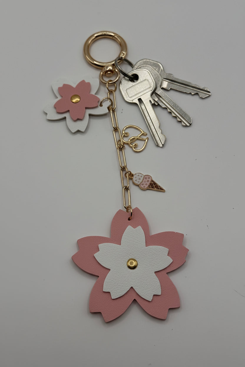 Pink and white layered sakura flower charm keychain with gold heart and ice cream cone charm on gold paperclip chain