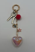 Iridescent holographic heart charm keychain with red pom-pom, rhinestone heart, and pink star charm on gold paperclip chain