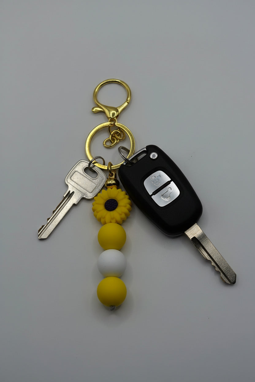 Yellow sunflower gold silicone beaded keychain with yellow and white beads and gold hardware