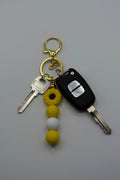Yellow sunflower gold silicone beaded keychain with yellow and white beads and gold hardware