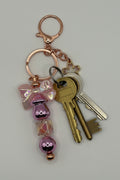 Lavender bow sakura rose gold beaded keychain with metallic purple beads and iridescent cube bead