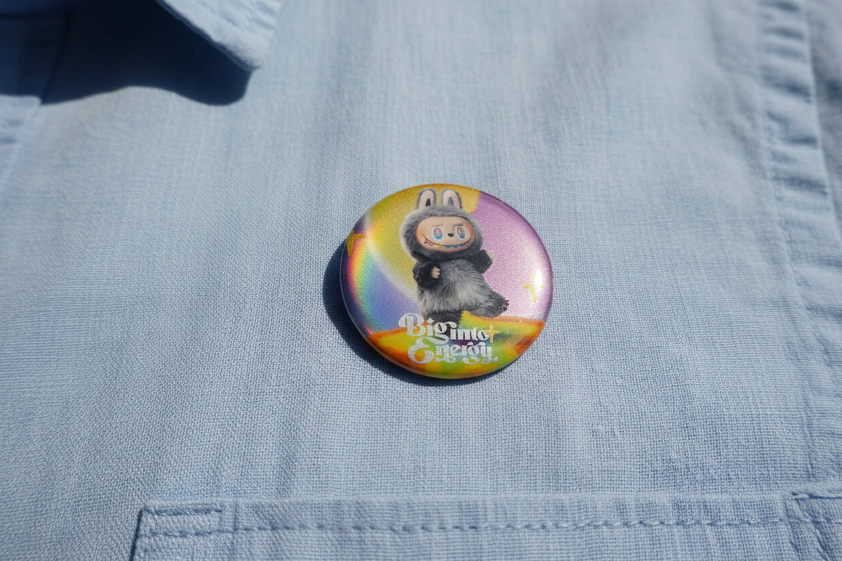 Round Labubu Big Into Energy character button pin beside a matching collectible card