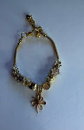 Gold dragonfly charm bracelet with flower, rose, clover and diamond charms on snake chain
