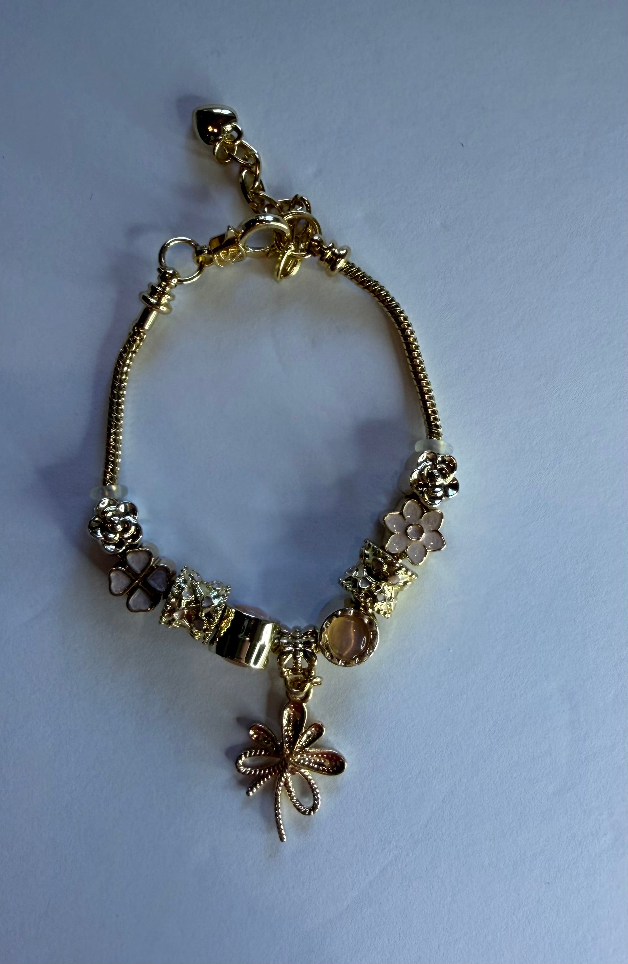 Gold dragonfly charm bracelet with flower, rose, clover and diamond charms on snake chain