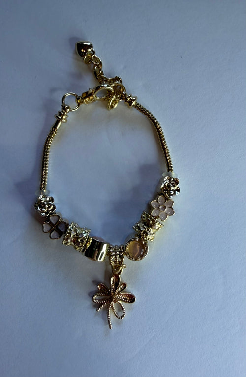 Gold dragonfly charm bracelet with flower, rose, clover and diamond charms on snake chain