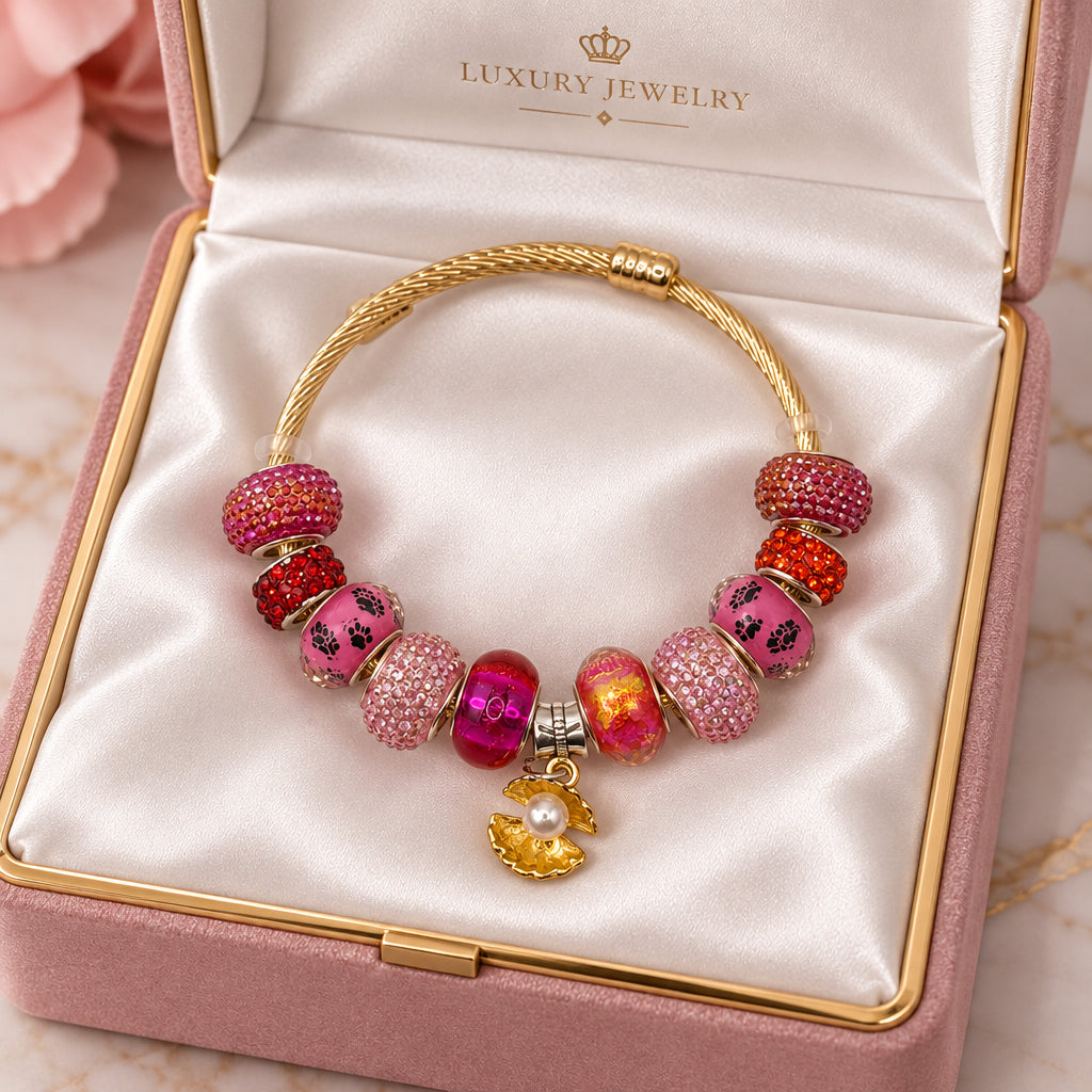Gold twisted cable charm bangle bracelet with pink and orange paw print beads and gold pearl flower charm