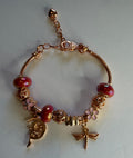 Rose gold fairy and dragonfly charm bracelet with red glass beads and pink flower charm