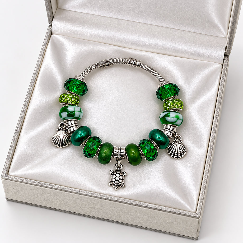 Silver twisted wire bangle bracelet with green crystal beads, rhinestone pave beads, murano glass beads, and silver turtle and shell charms