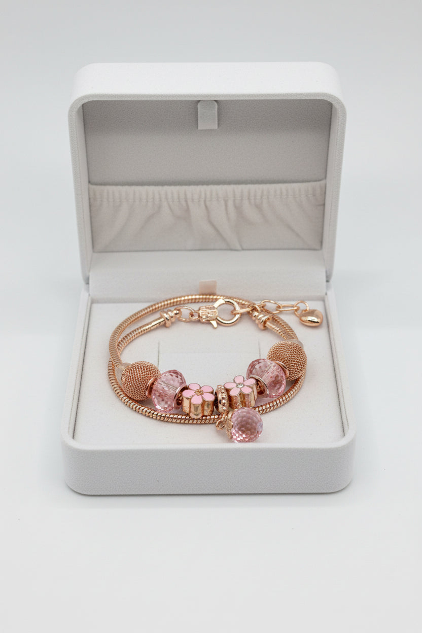 Rose gold snake chain bracelet with pink crystal beads, mesh ball beads, enamel daisy flower charms, and dangling crystal ball pendant