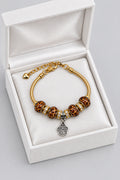 Gold snake chain bracelet with leopard print beads, rhinestone spacers, and dangling silver paw print charm