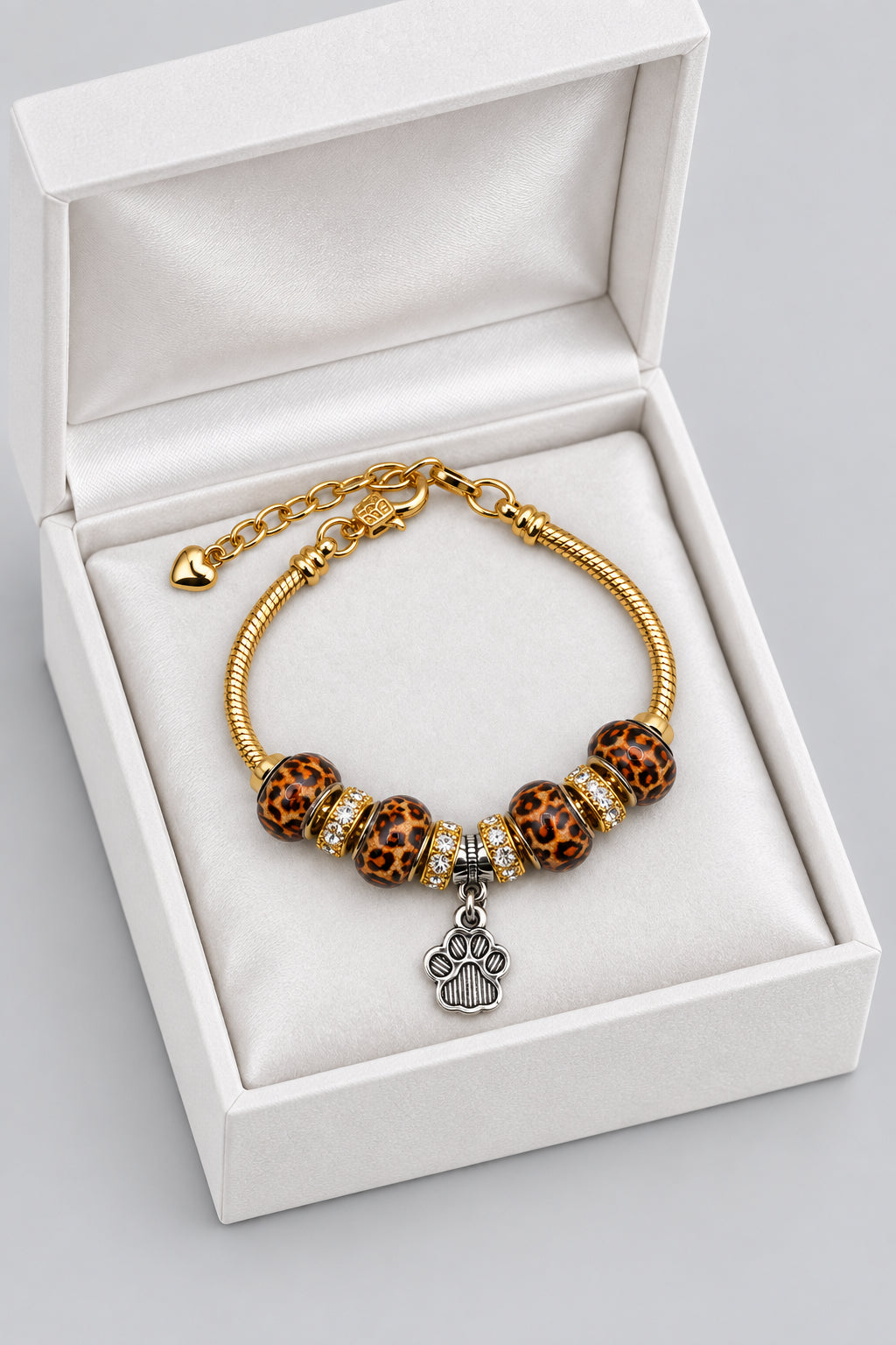 Gold snake chain bracelet with leopard print beads, rhinestone spacers, and dangling silver paw print charm
