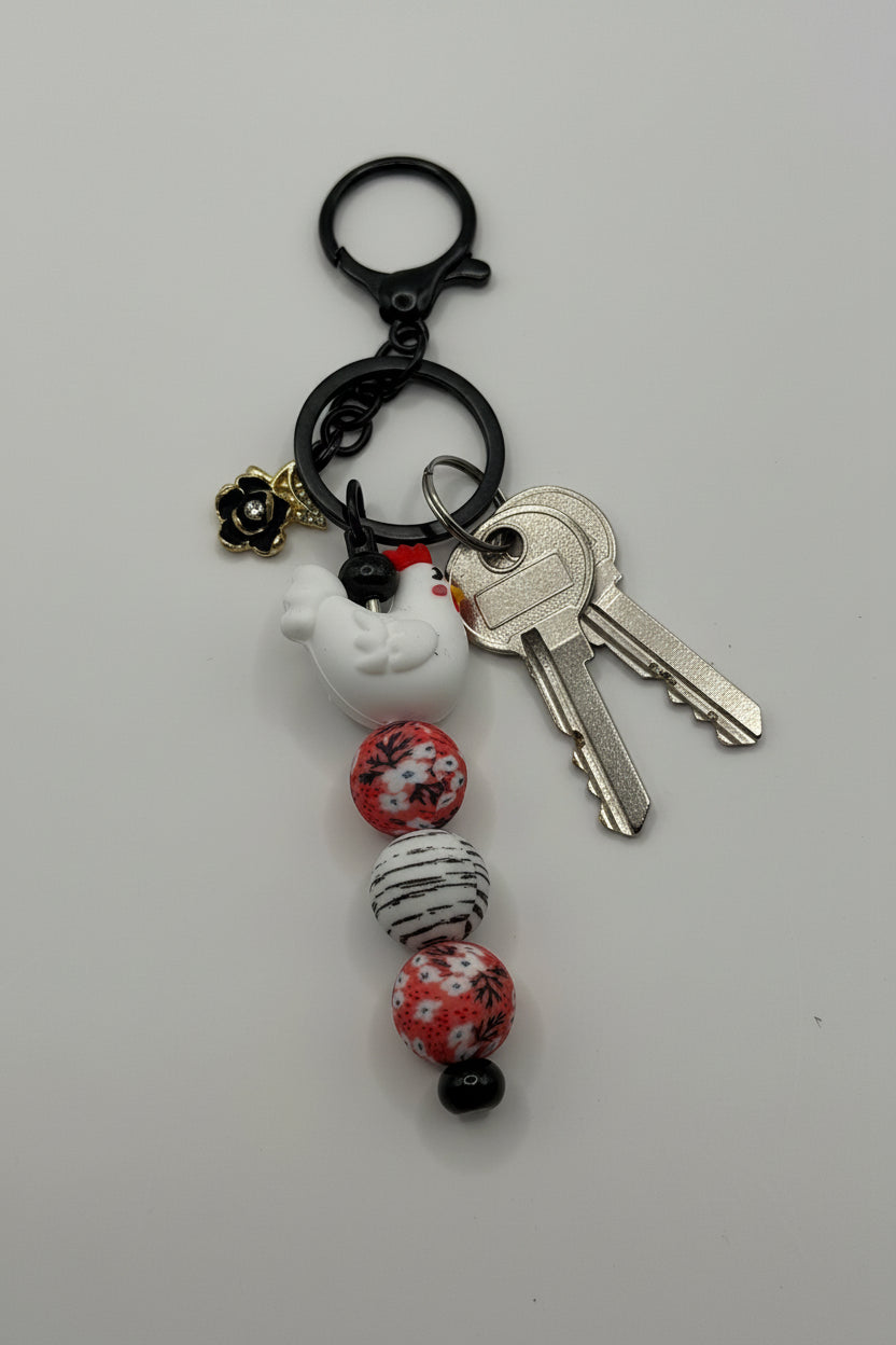 White chicken charm beaded keychain with pink floral beads and black hardware