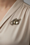 Champagne crystal bow brooch with large faceted gemstone center on display card