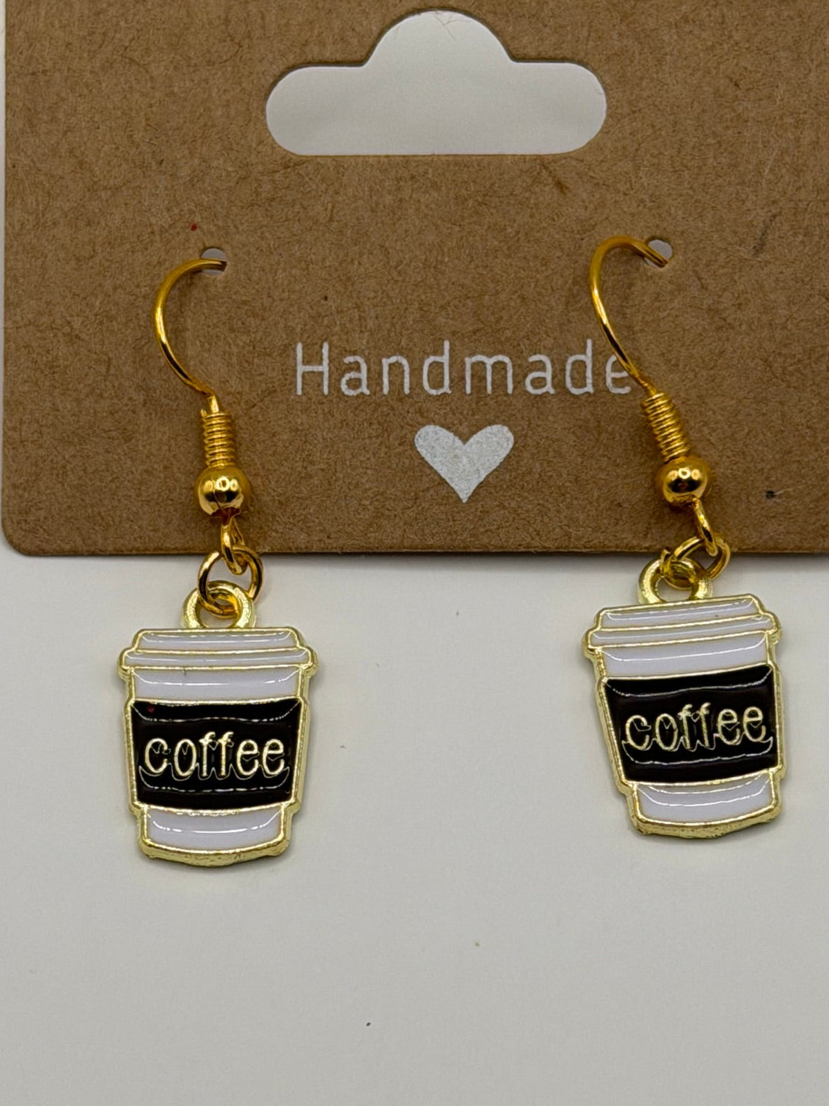 Handmade enamel coffee cup dangle earrings with black sleeve and white lid on gold fish hook backs