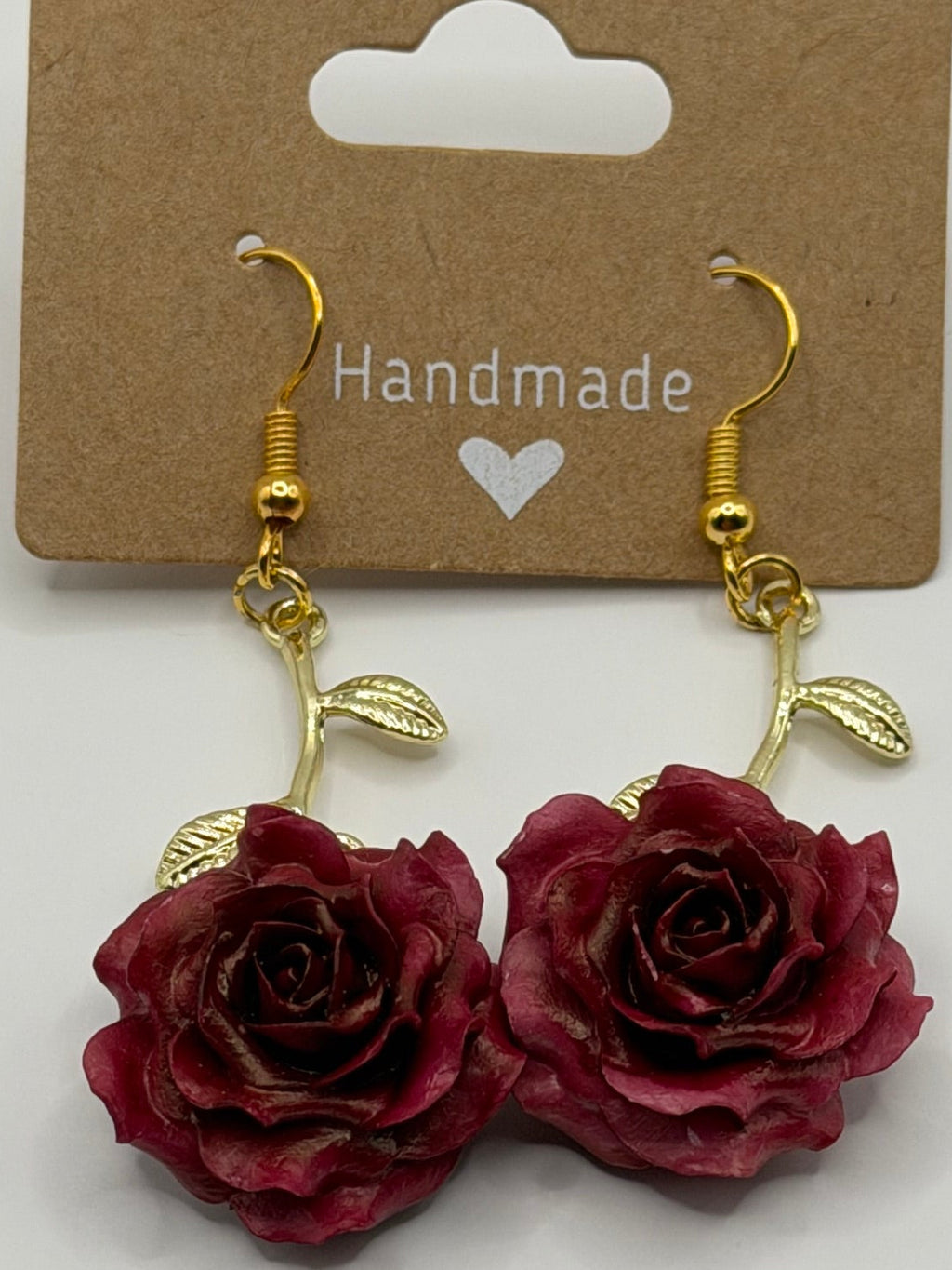 Handmade burgundy rose dangle earrings with gold-tone stem and leaf detail on gold fish hook backs