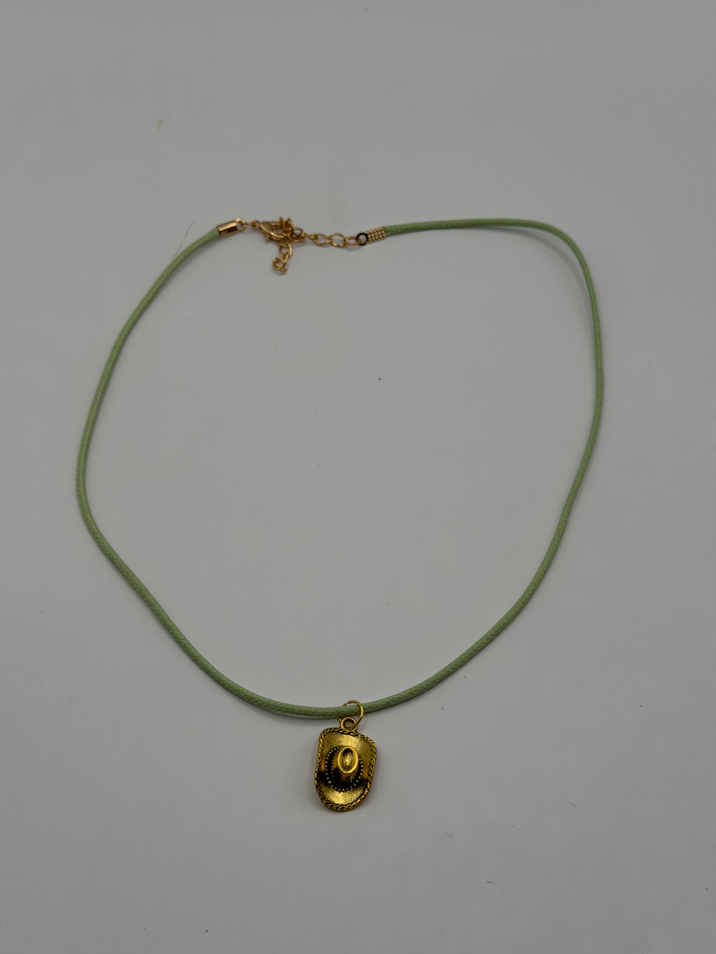 Handmade sage green cord necklace with antique gold cowboy hat charm and gold adjustable extender chain