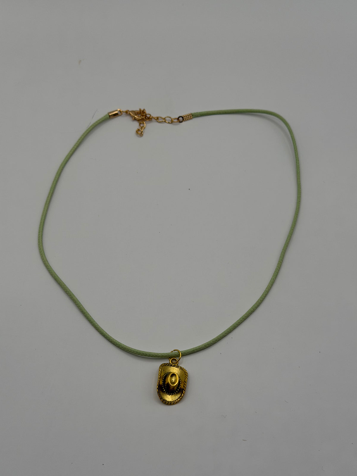 Handmade sage green cord necklace with antique gold cowboy hat charm and gold adjustable extender chain