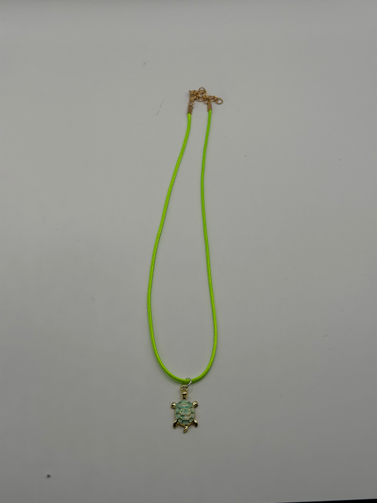 Handmade neon yellow-green cord necklace with gold and mint enamel sea turtle charm and gold adjustable extender chain
