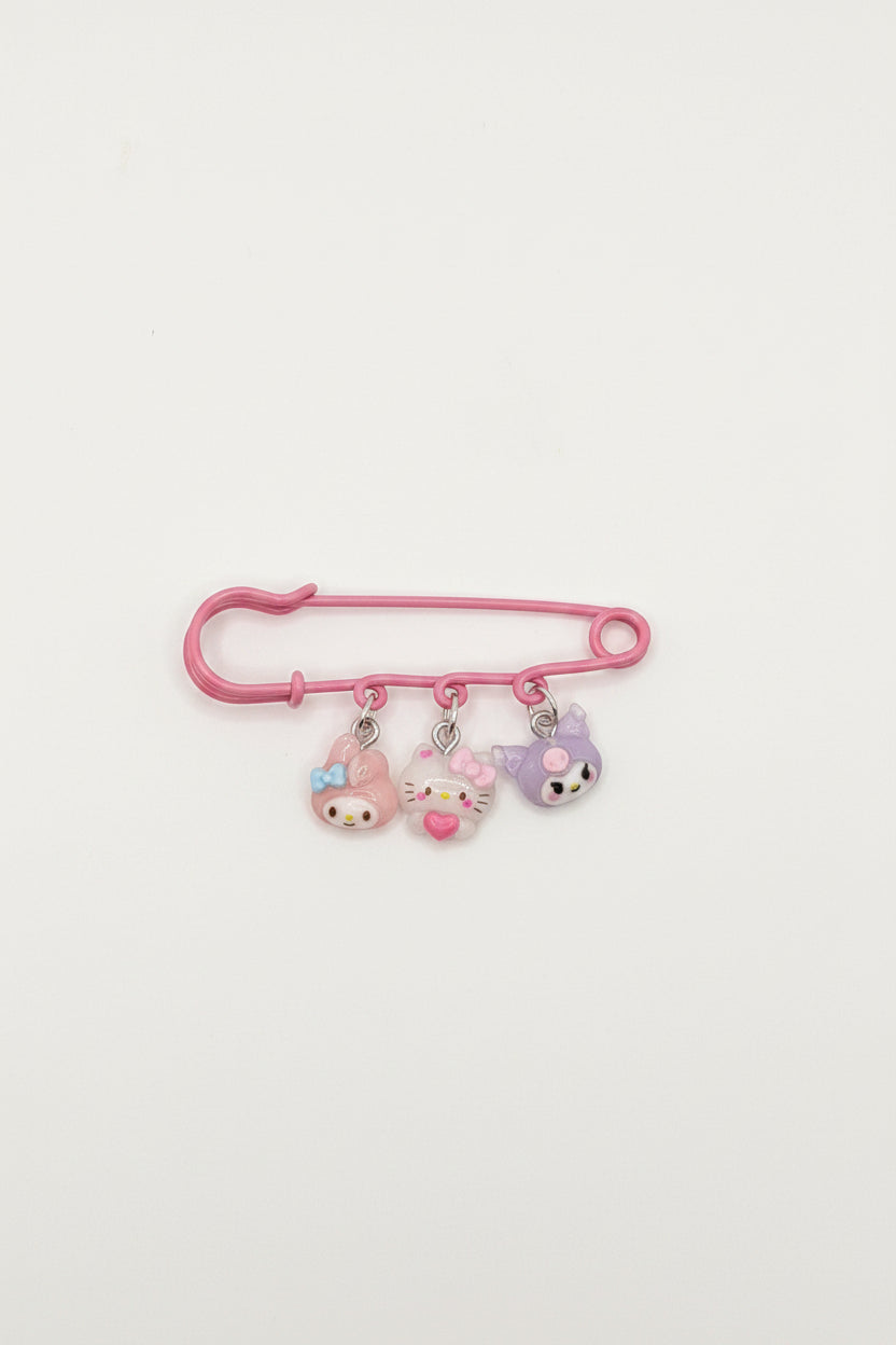 Handmade pink safety pin with Hello Kitty and Kuromi-inspired character charms on a kraft Handmade display card