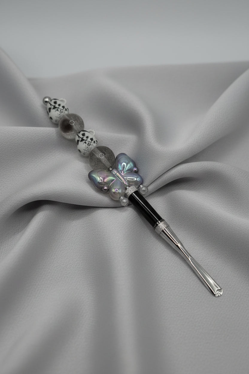 Black seam ripper with iridescent gray butterfly charm and frosted beaded handle