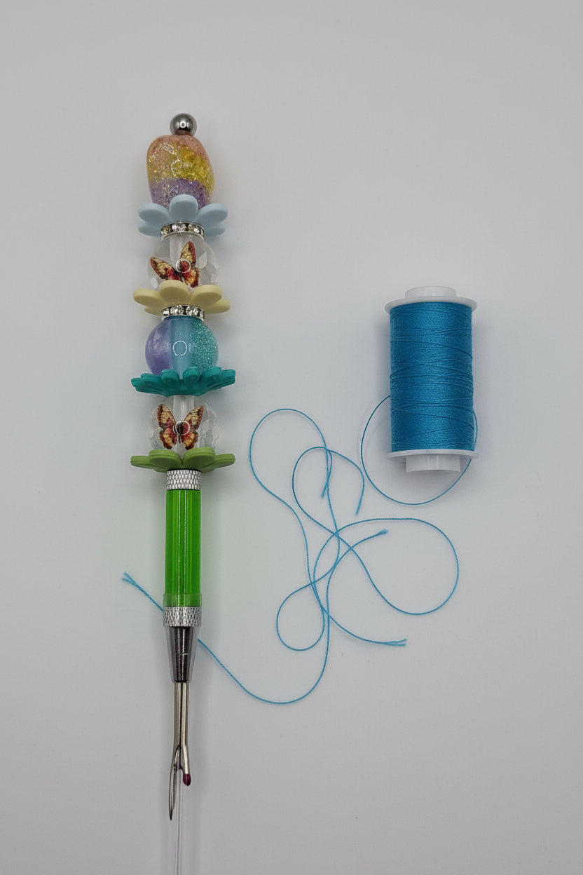 Green seam ripper with butterfly charms and colorful flower beaded handle