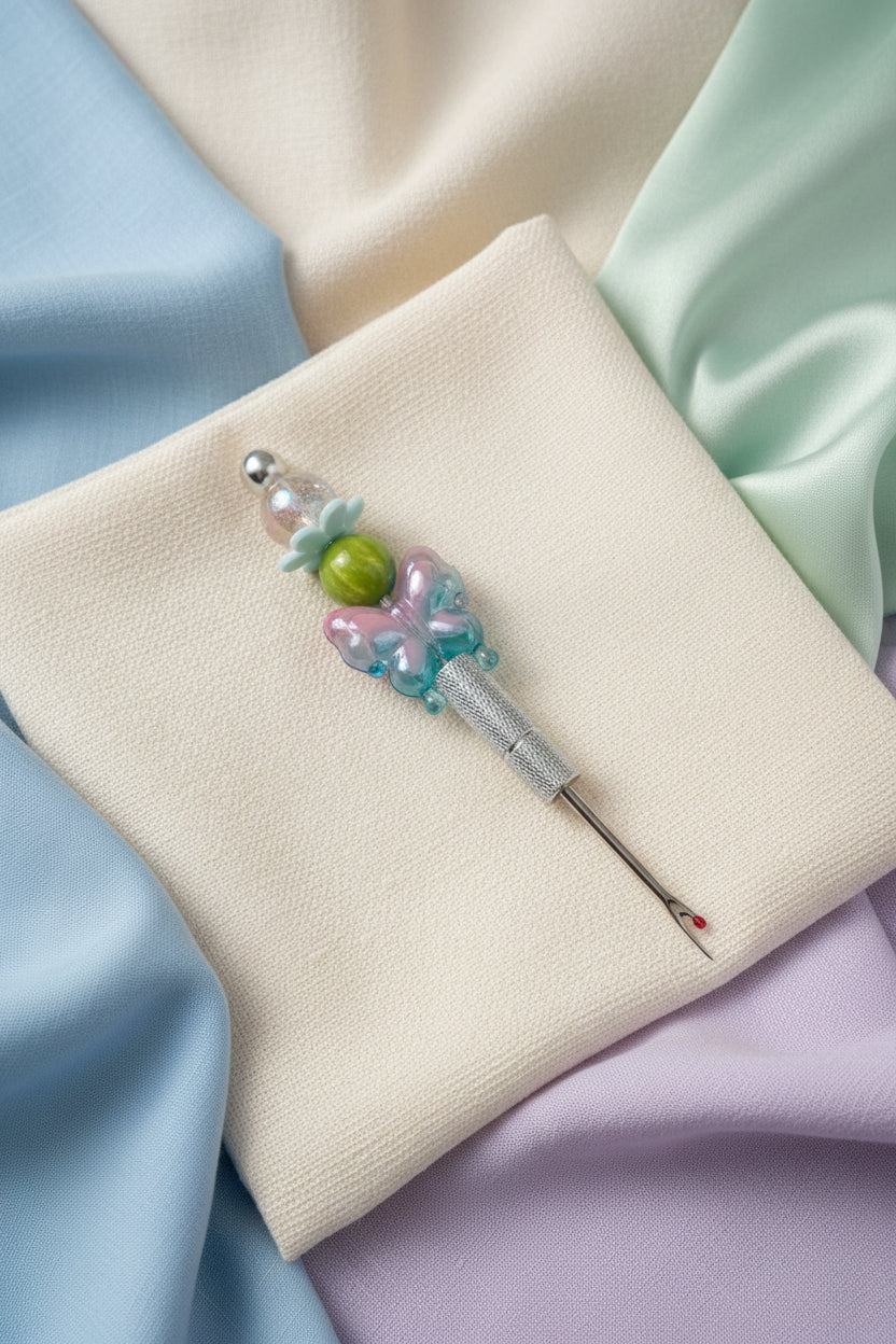 Silver seam ripper with pink and teal butterfly charm and pastel beaded handle